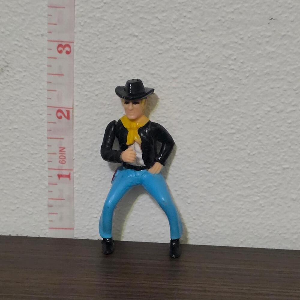 Vintage 1970s cowboy action figure with black hat, black jacket, yellow scarf, a